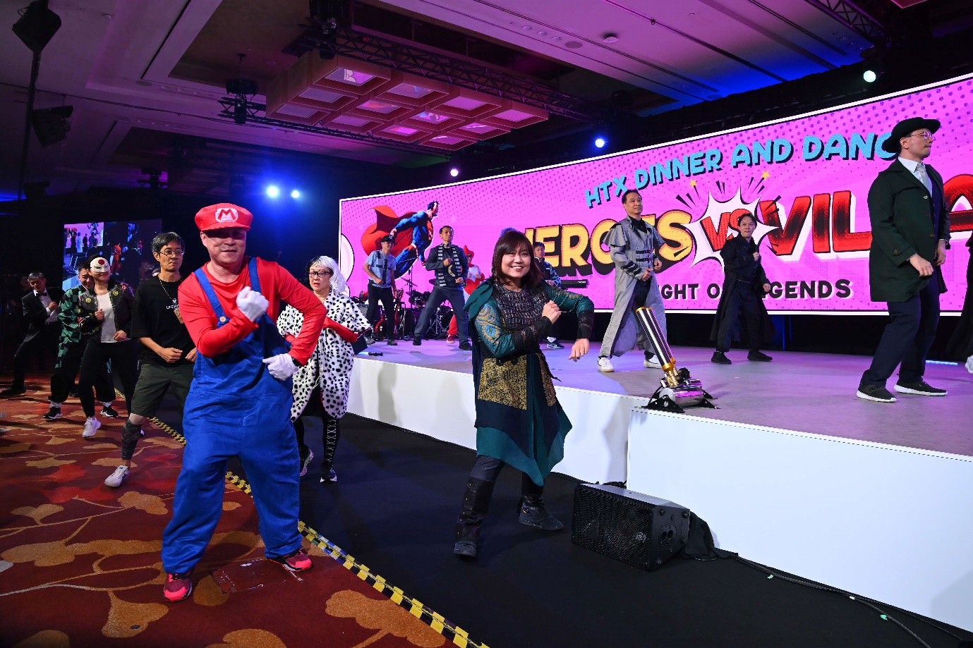 A group of people dancing on and in front of a stage.