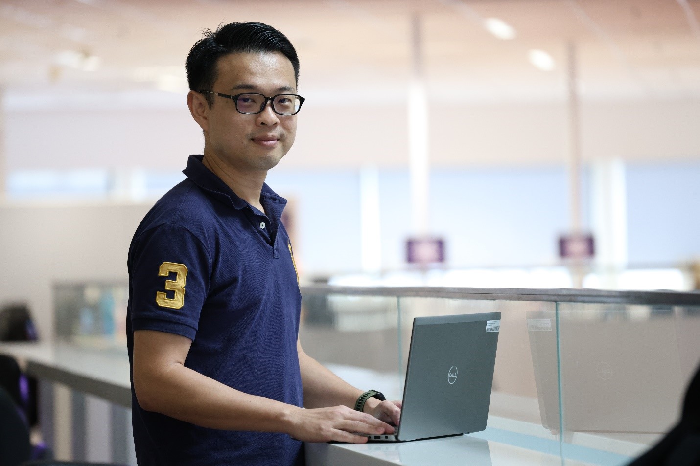 A man standing in front of a computer.
