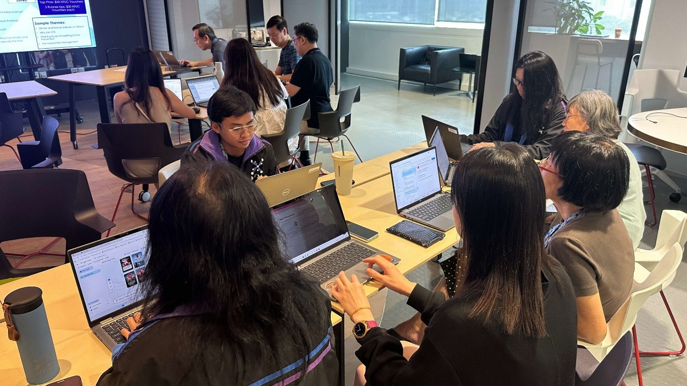 A group of people sitting at a table with laptops.