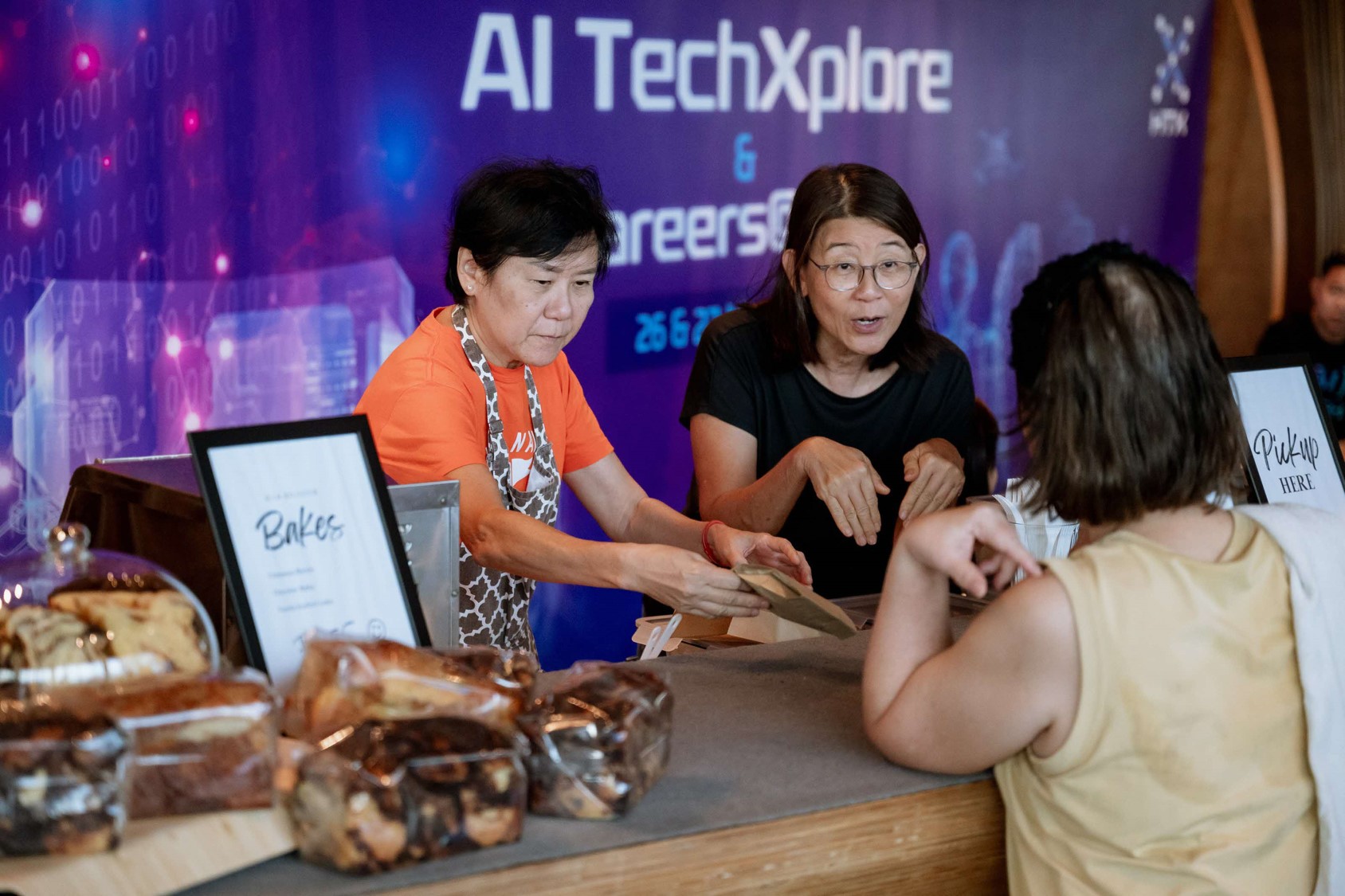 Counter ladies serving baked goods.