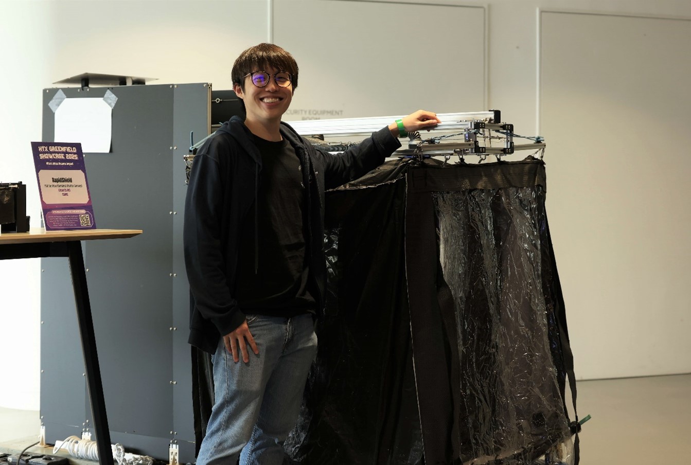 A man smiling and standing next to a machine.