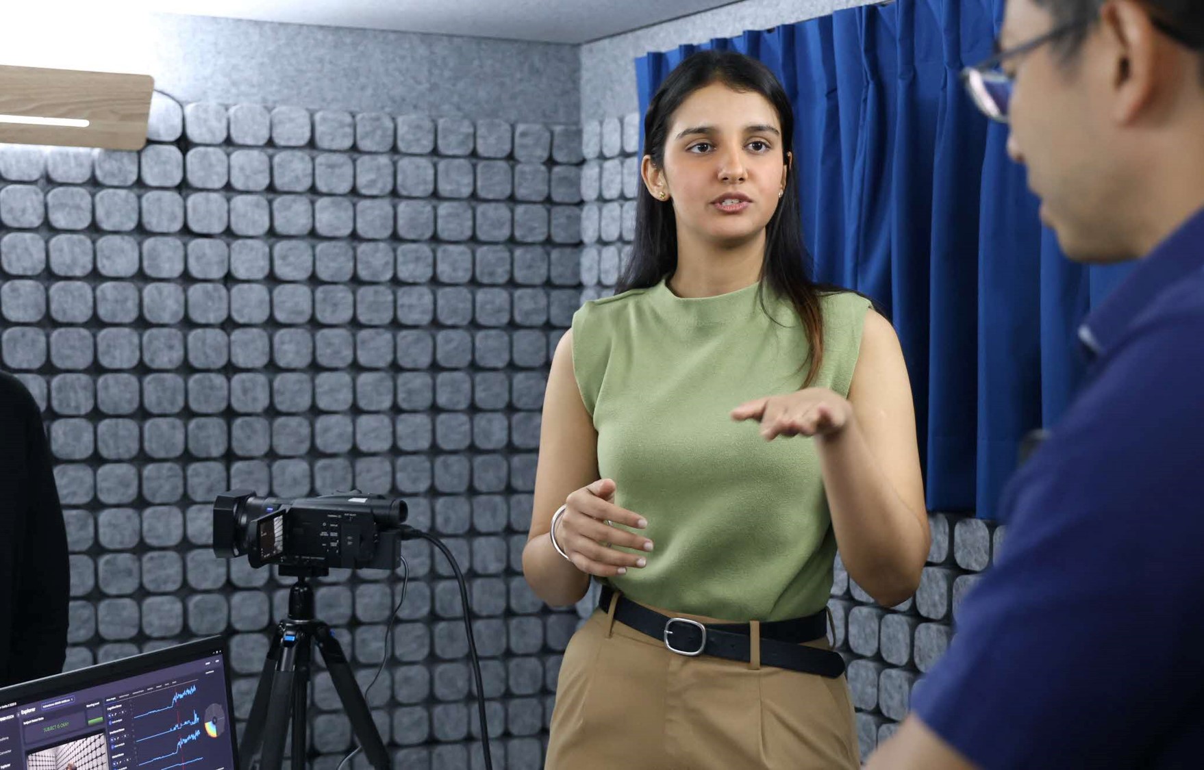 A woman talks in front of a camera.