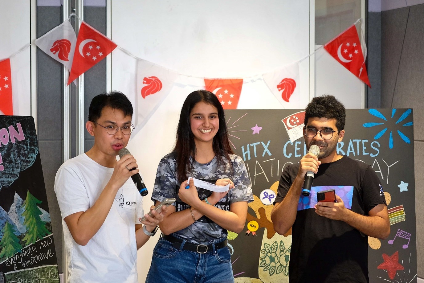 Two men and a woman standing in front of chalk boards.