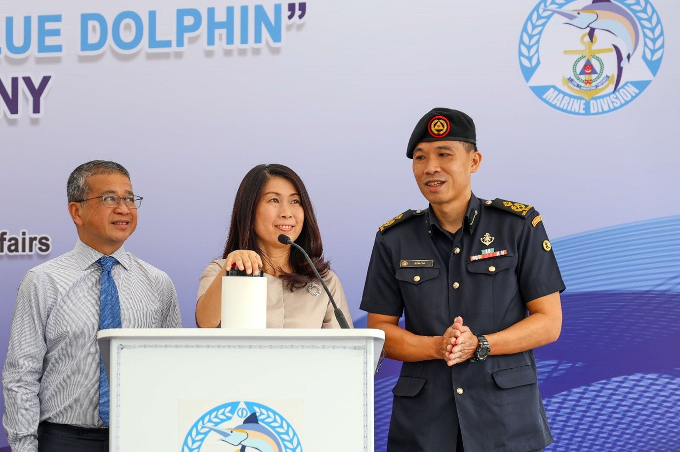 3 persons standing at a podium.