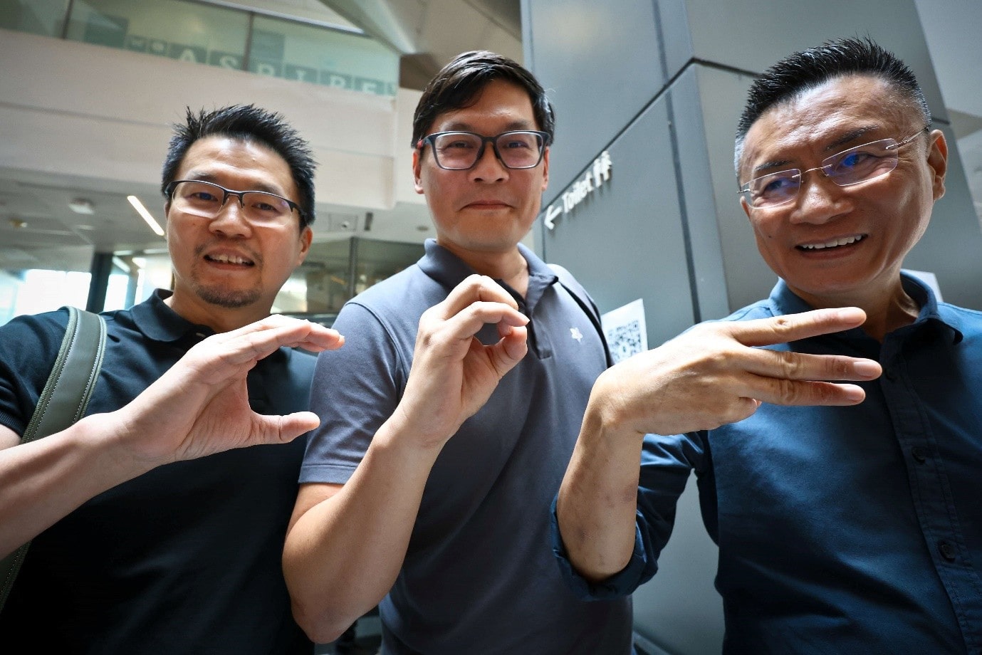 3 men standing with hand gestures