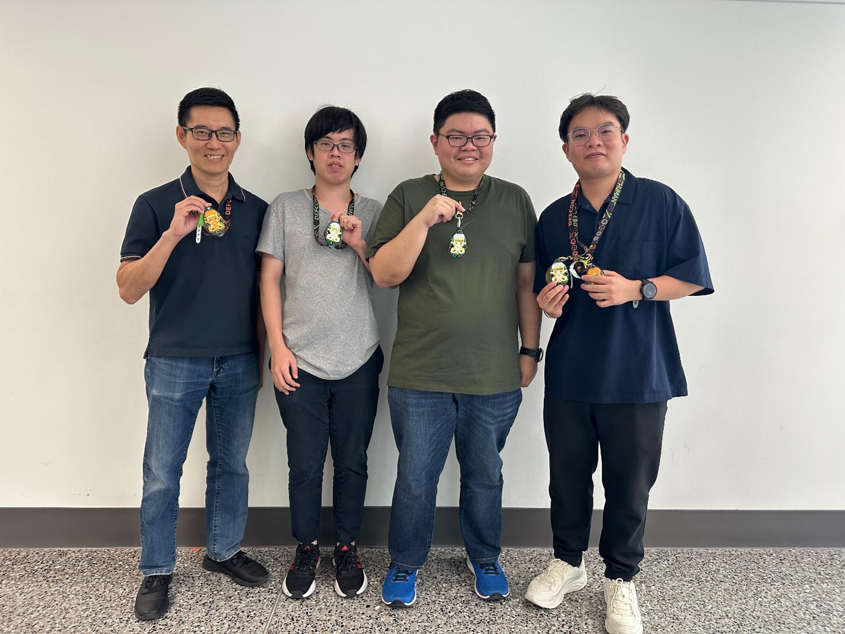 A group of four men posing for a photo at DEF CON 33.