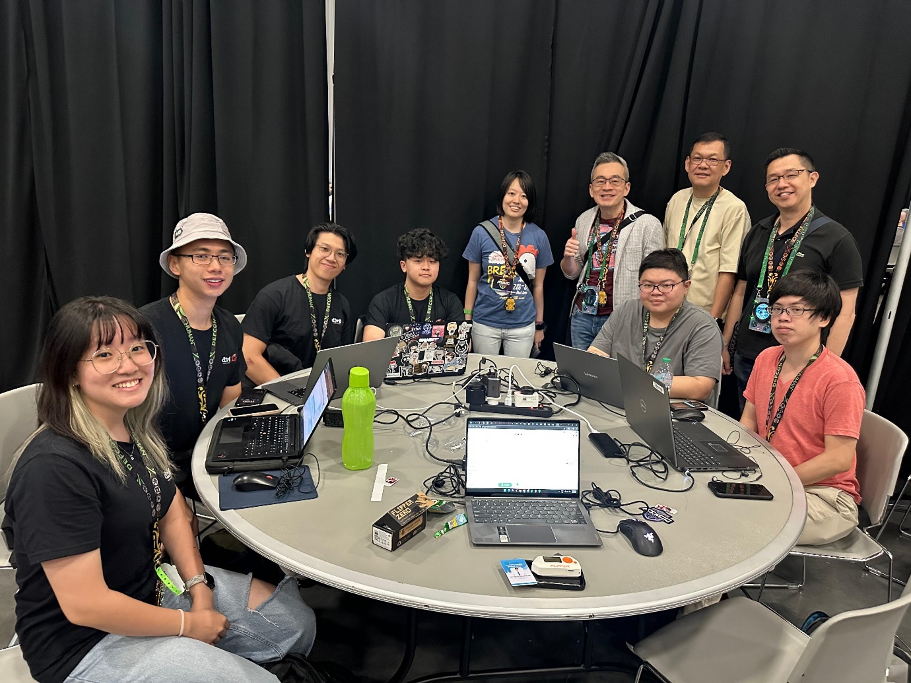 A group of people around a round table with laptops.