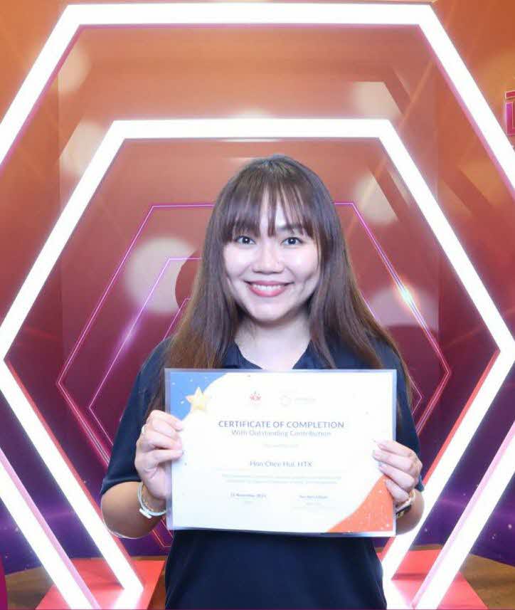 Woman standing with certificate.