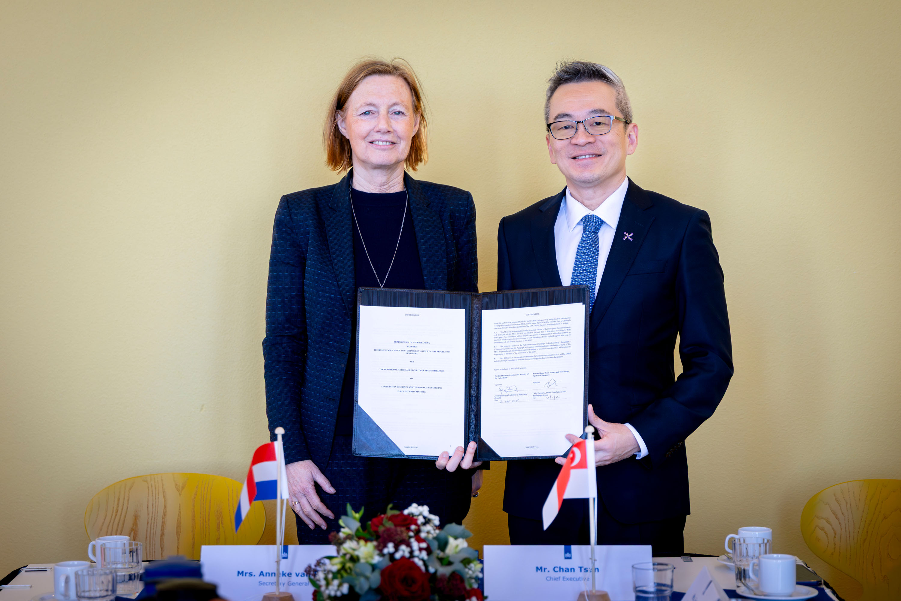 A woman and a man standing and holding a document.