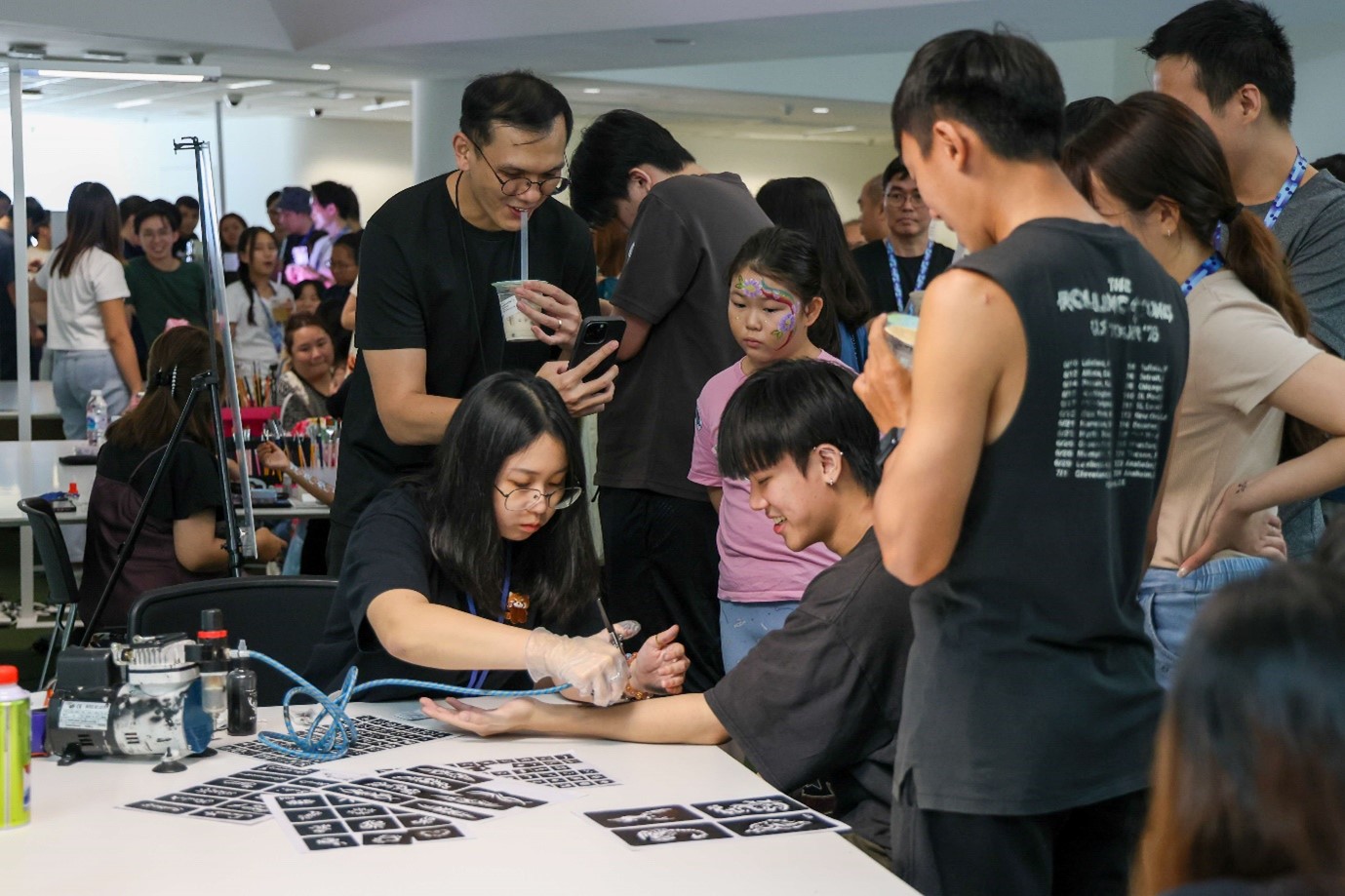 Families getting airbrush tattoos at the HTX Family Day 2025.