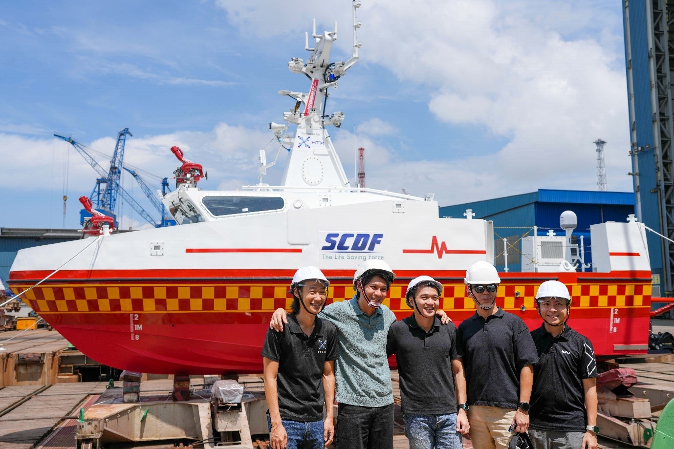 A group of people standing in front of a boat.