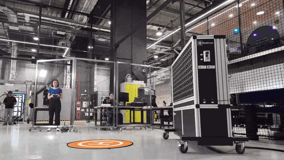 Indoor testing facility with a woman operating a drone.