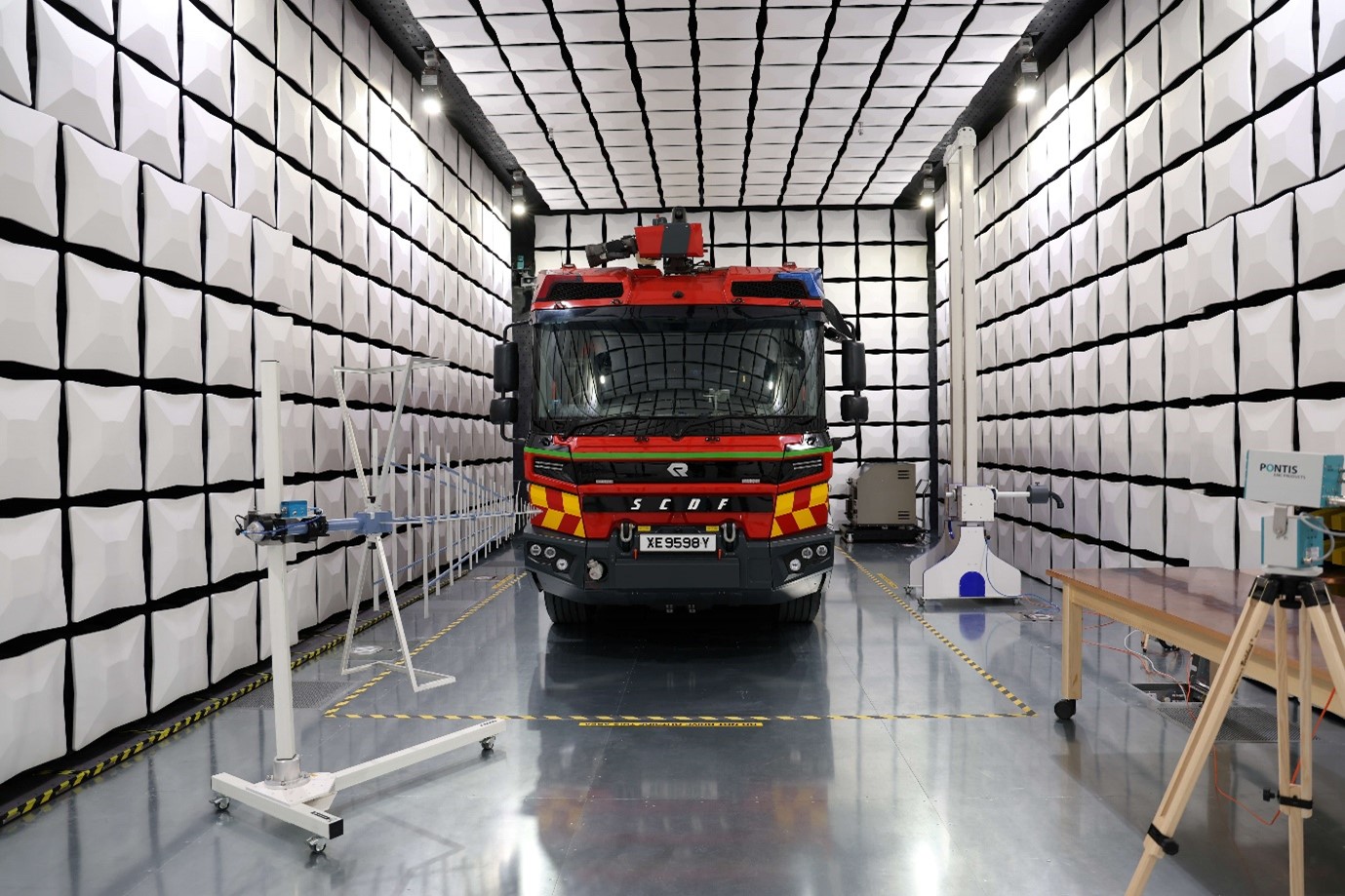 A red truck in a room filled with white tiles.
