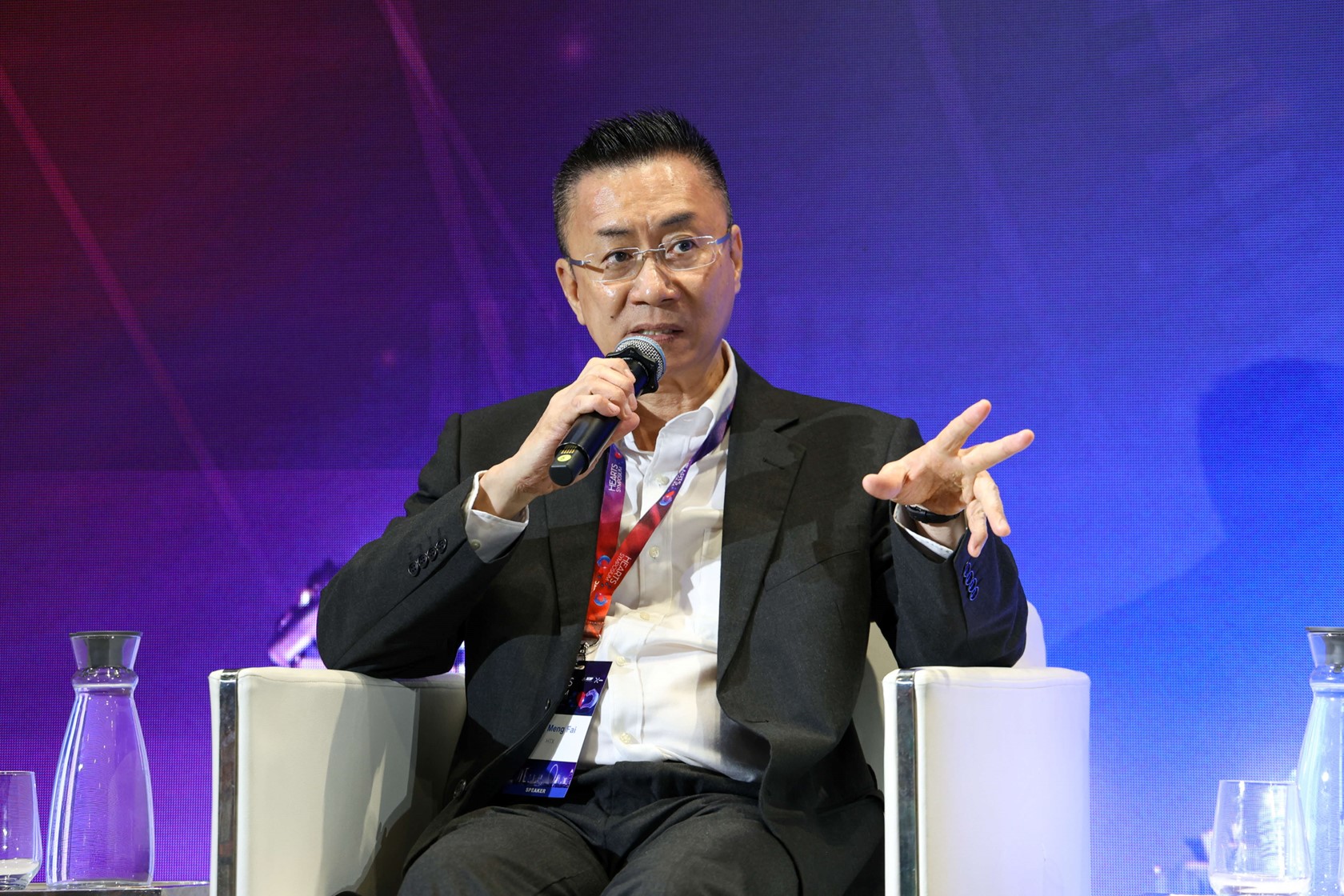 A man sitting in a chair holding a microphone.