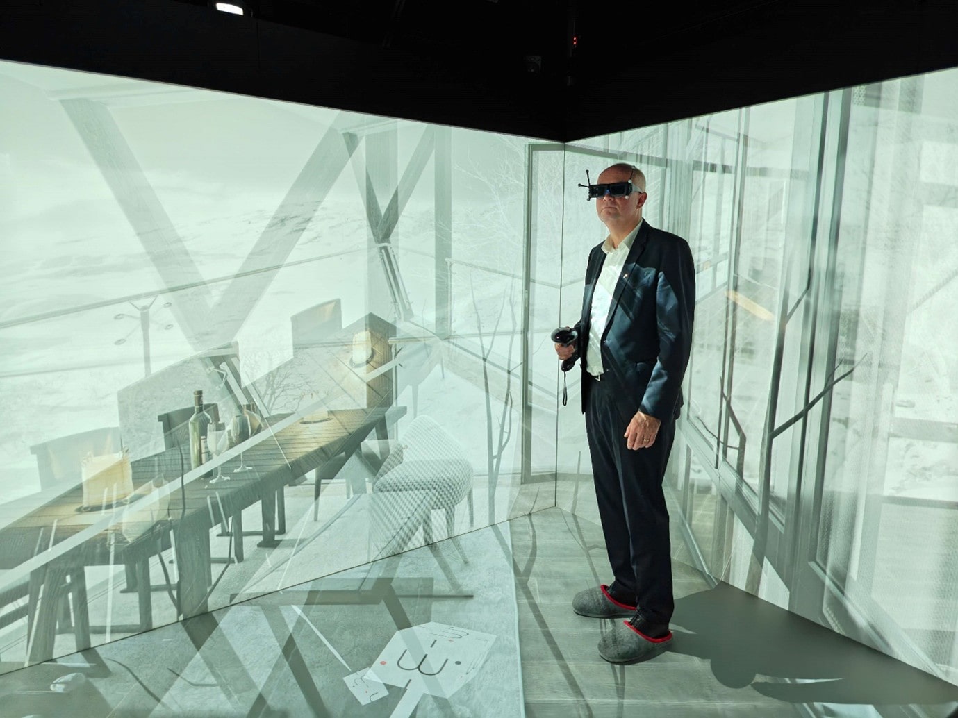 A man in a room with light projections wearing goggles.