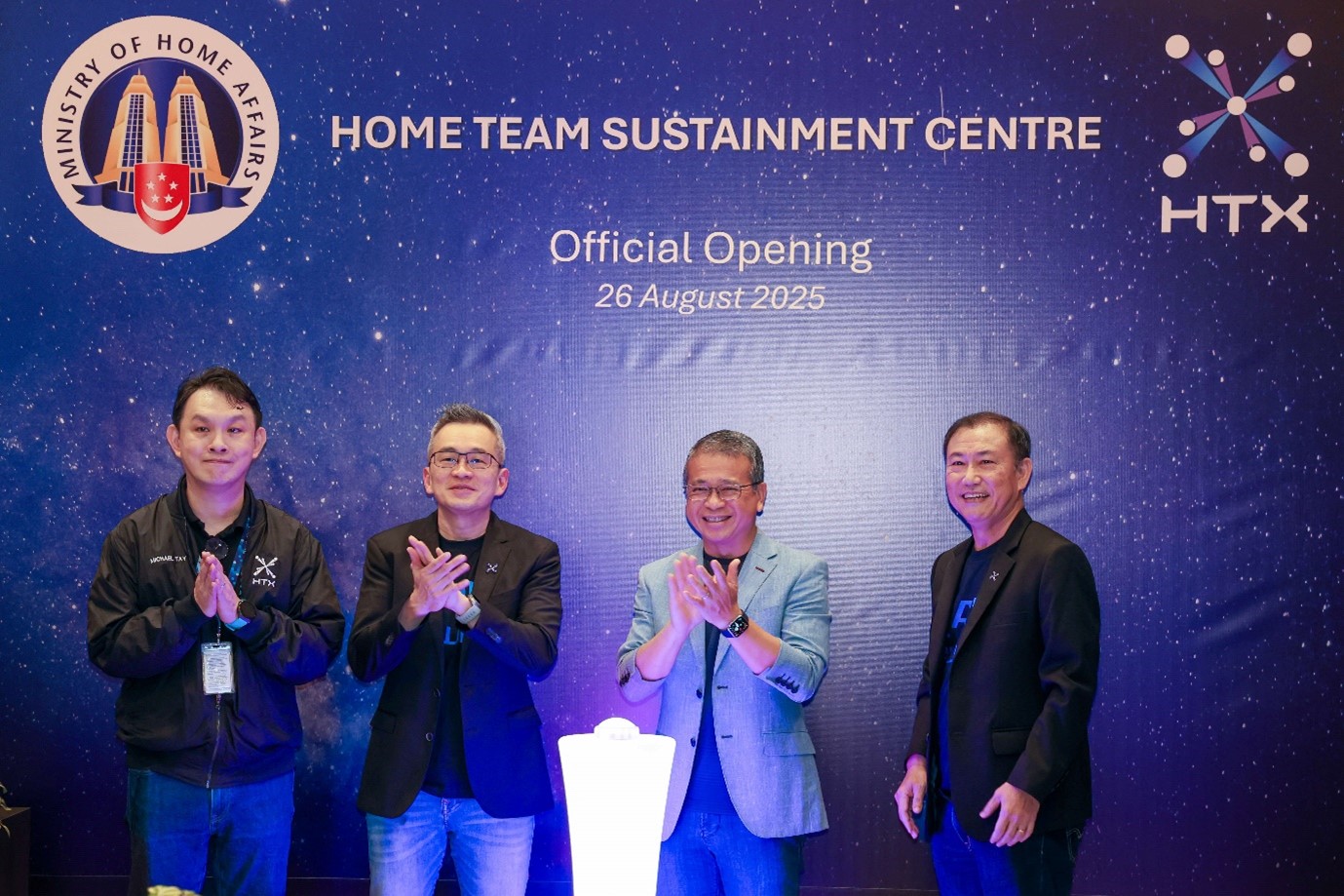 Four men at the official opening of HTSC, standing in front of a backdrop with the Ministry of Home Affairs and HTX logos.