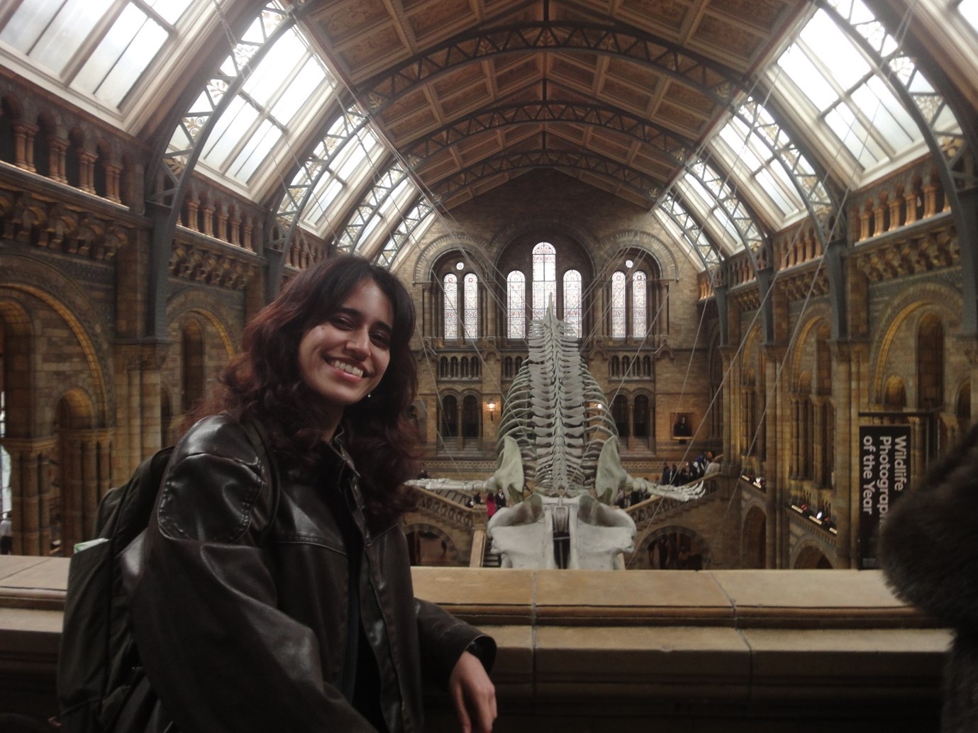 A young woman standing in front of a grand skeleton display.