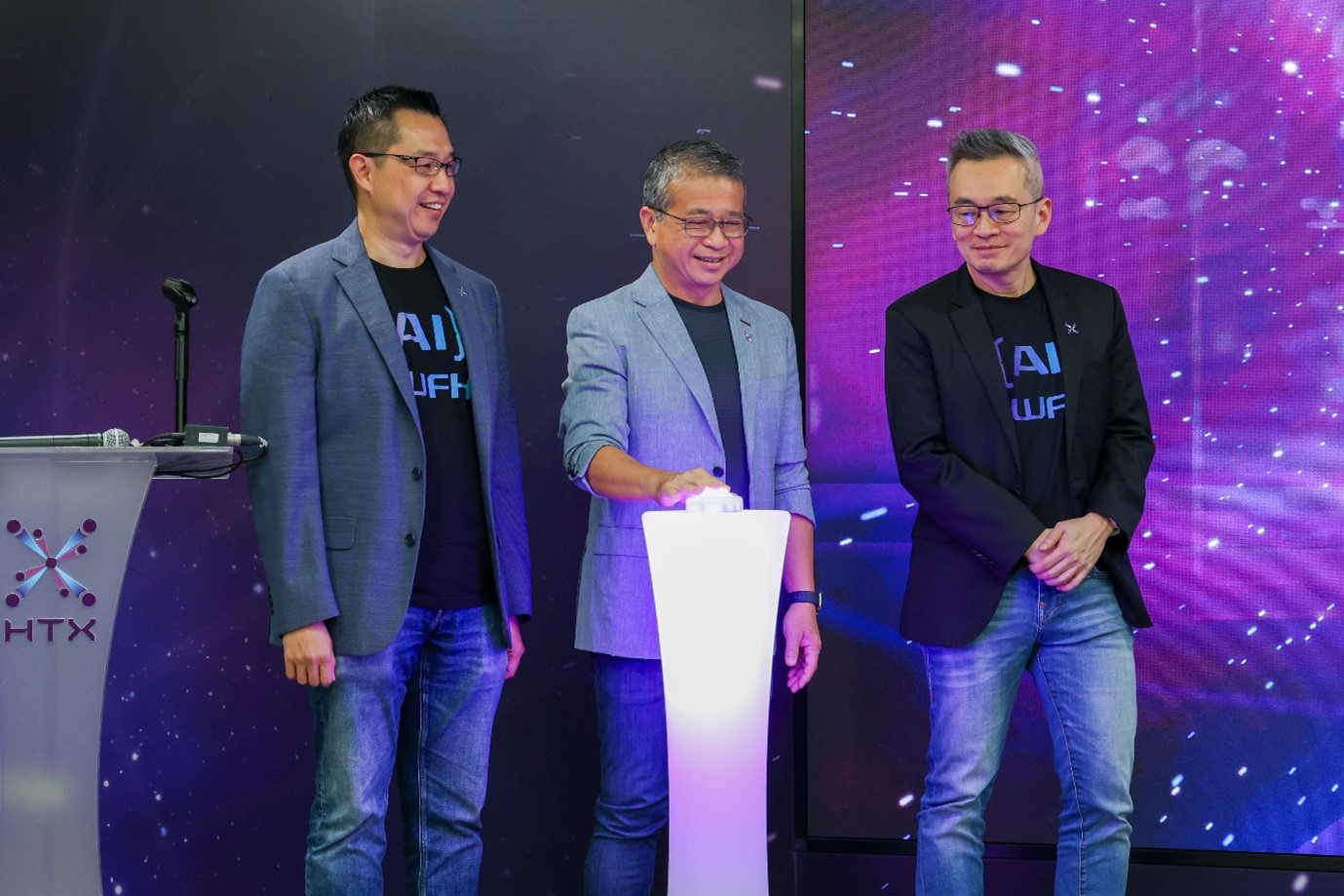 Three men standing next to a white pedestal with a button.