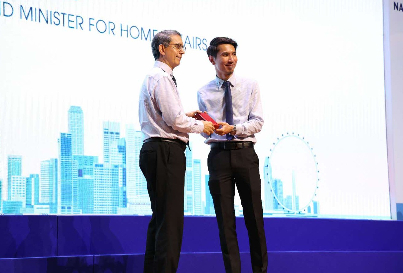 A man presenting an award to another man on stage.