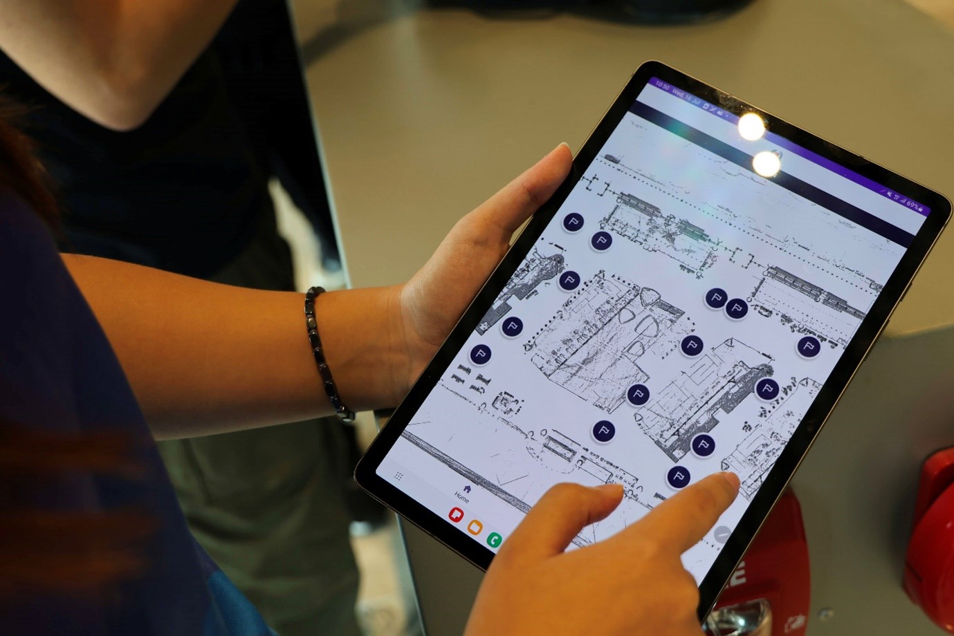 A person navigating a digital floor plan on a tablet.