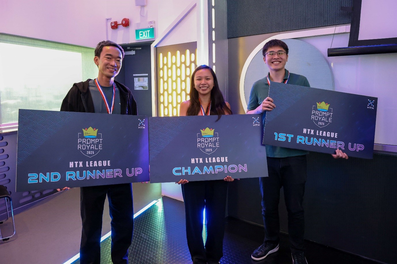 Three winners holding large award boards for the HTX Prompt Royale 2025 competition.