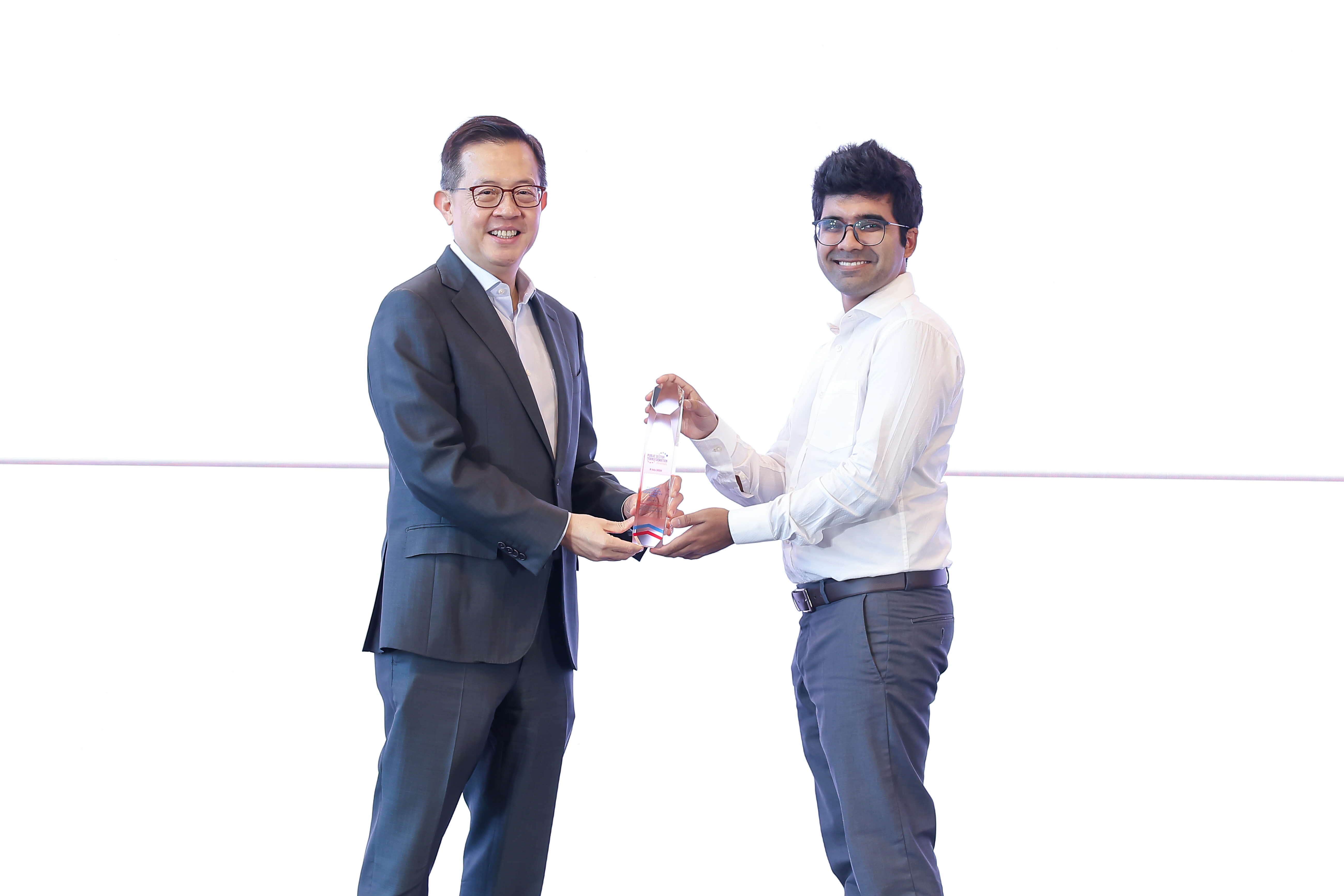 One man giving an award to another man.