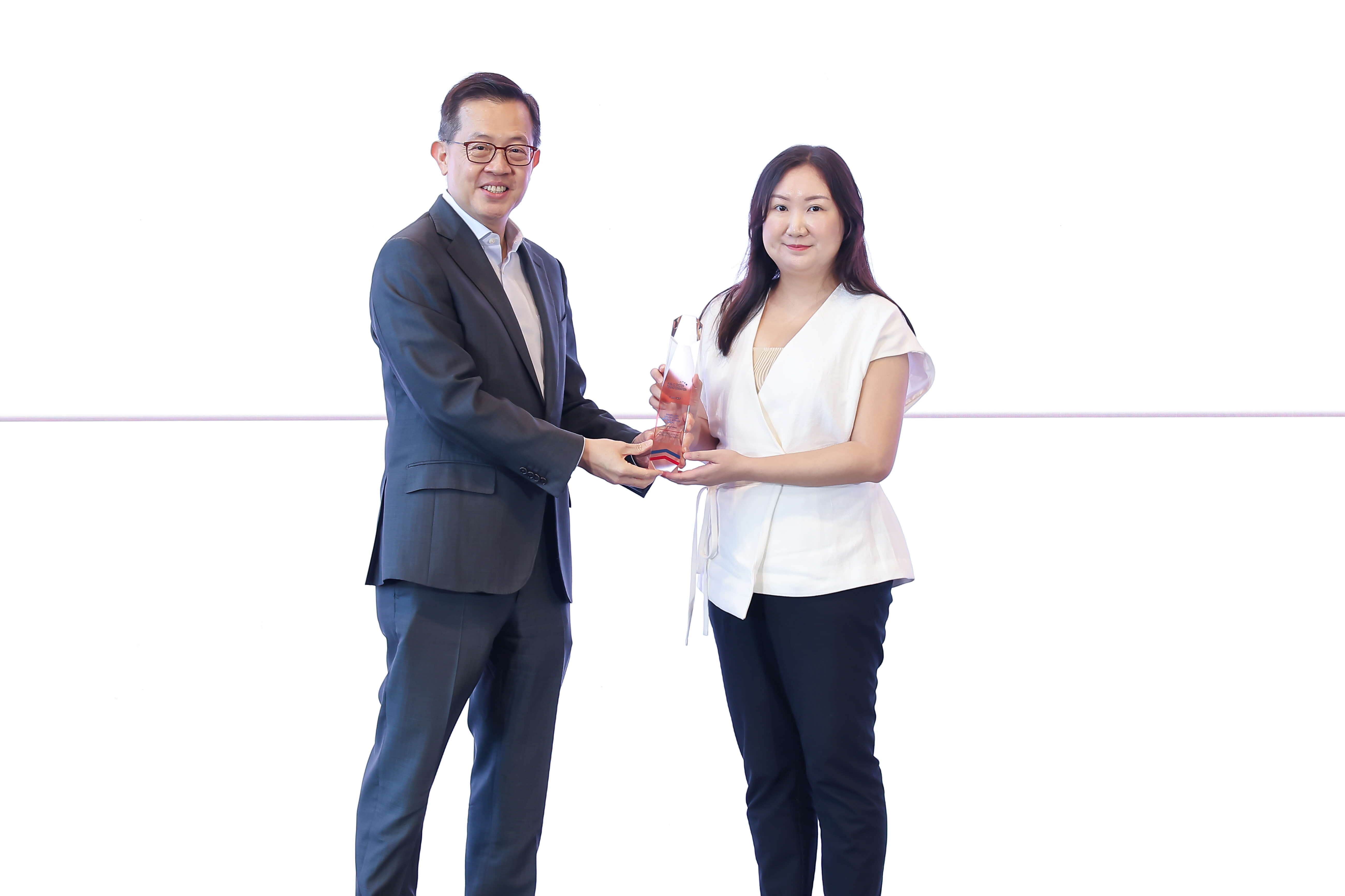 One man giving an award to a woman.
