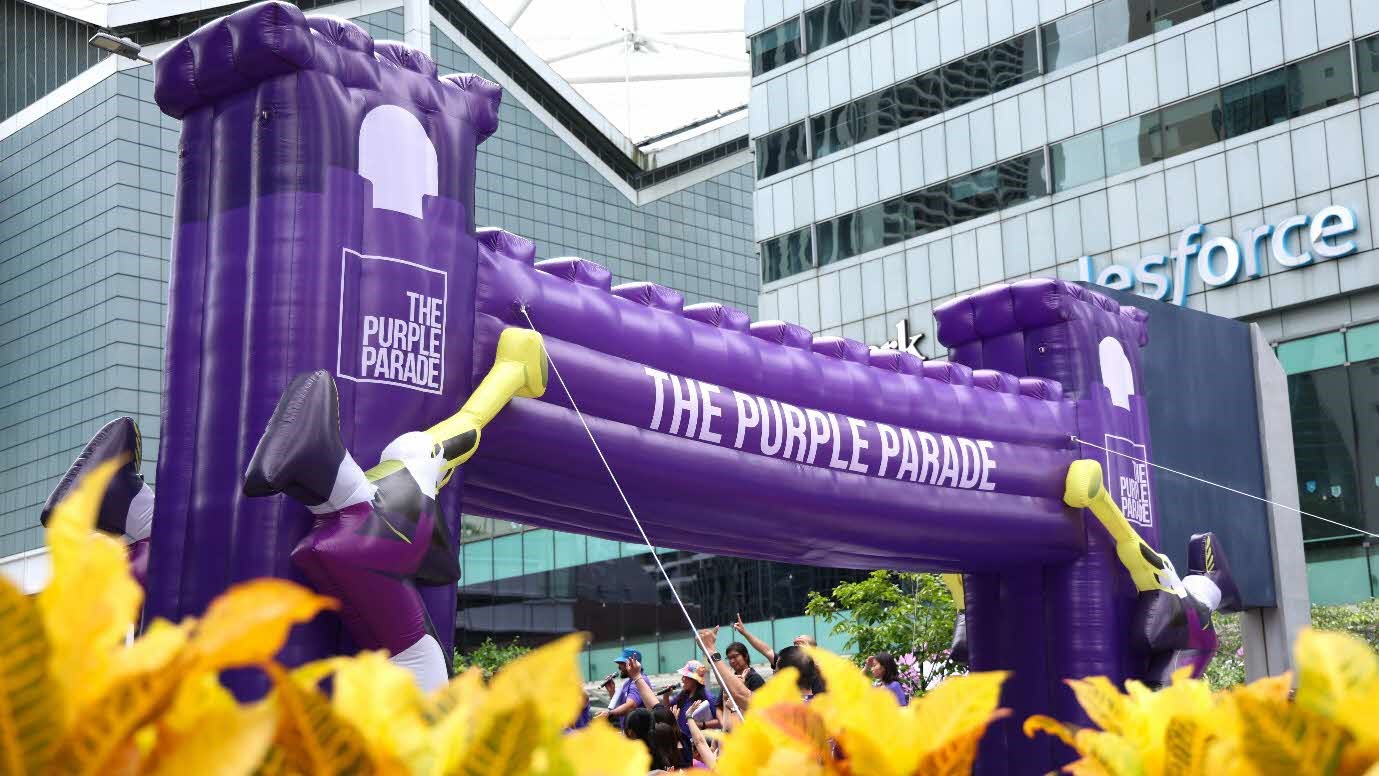 A purple inflatable archway with people in the background.