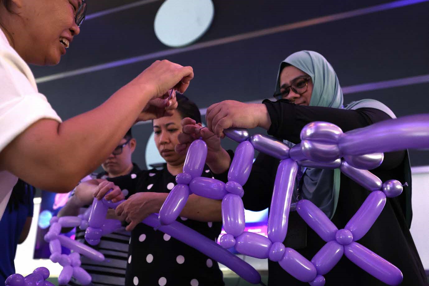 A group of people making a balloon structure.