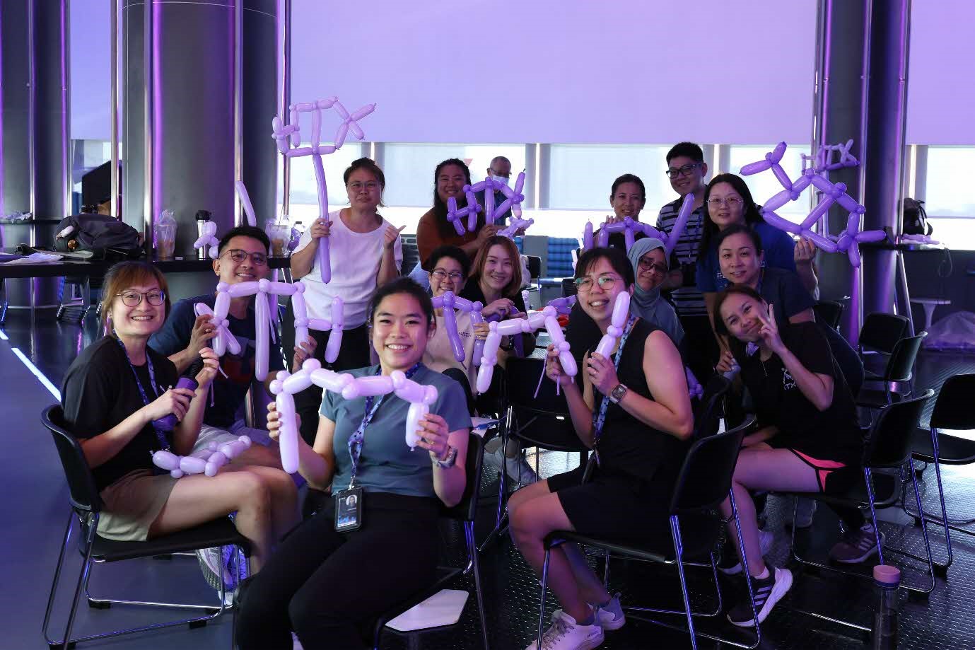 A group of people holding up balloons.