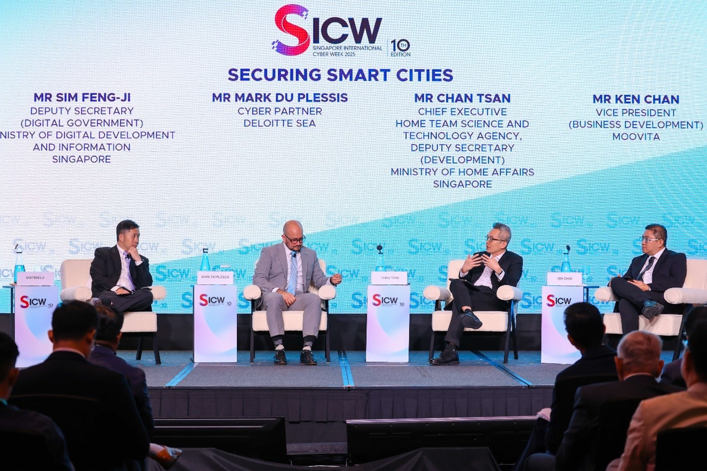 Four male panellists, including HTX Chief Executive Chan Tsan, are seated on stage in front of an audience.