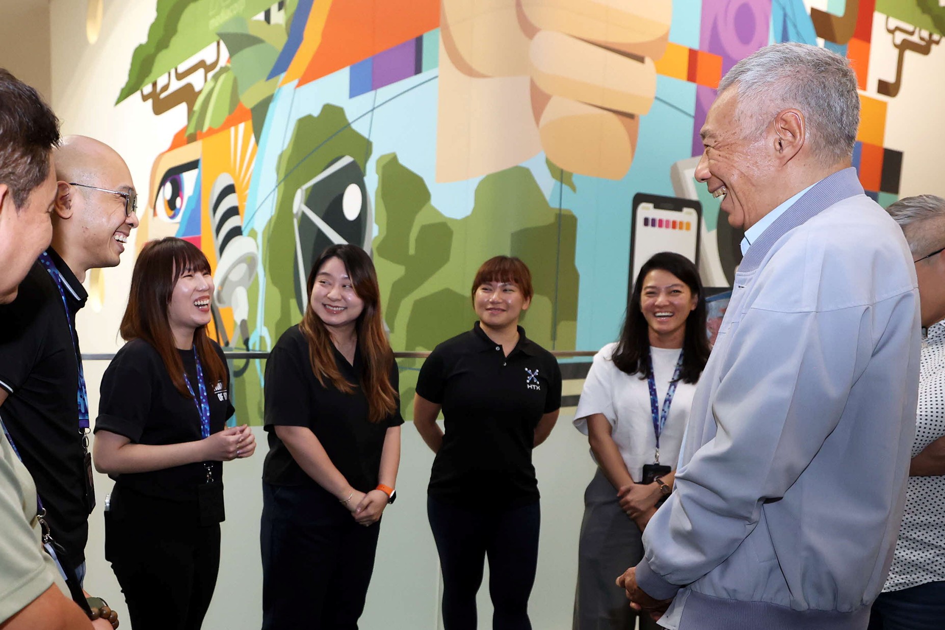 A group of people standing in a circle and laughing.