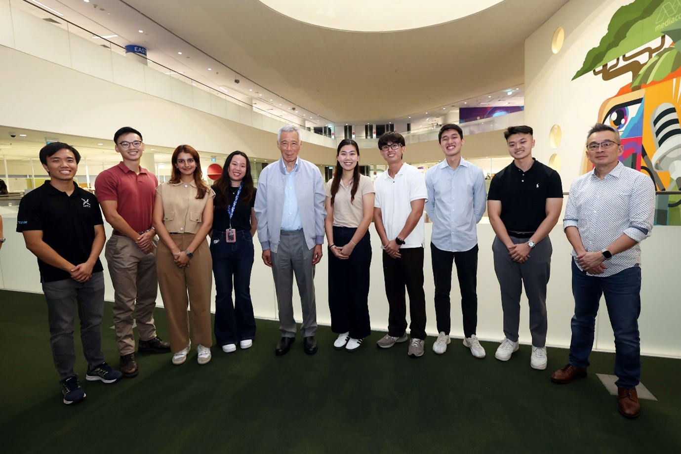 A group of people standing in a line as they pose for a photo.