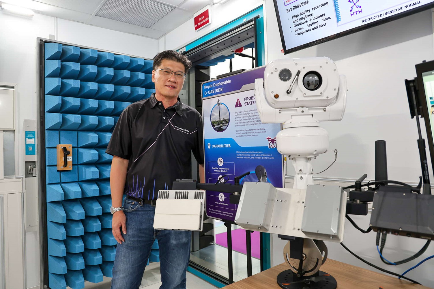 A man standing next to a poster and machine.