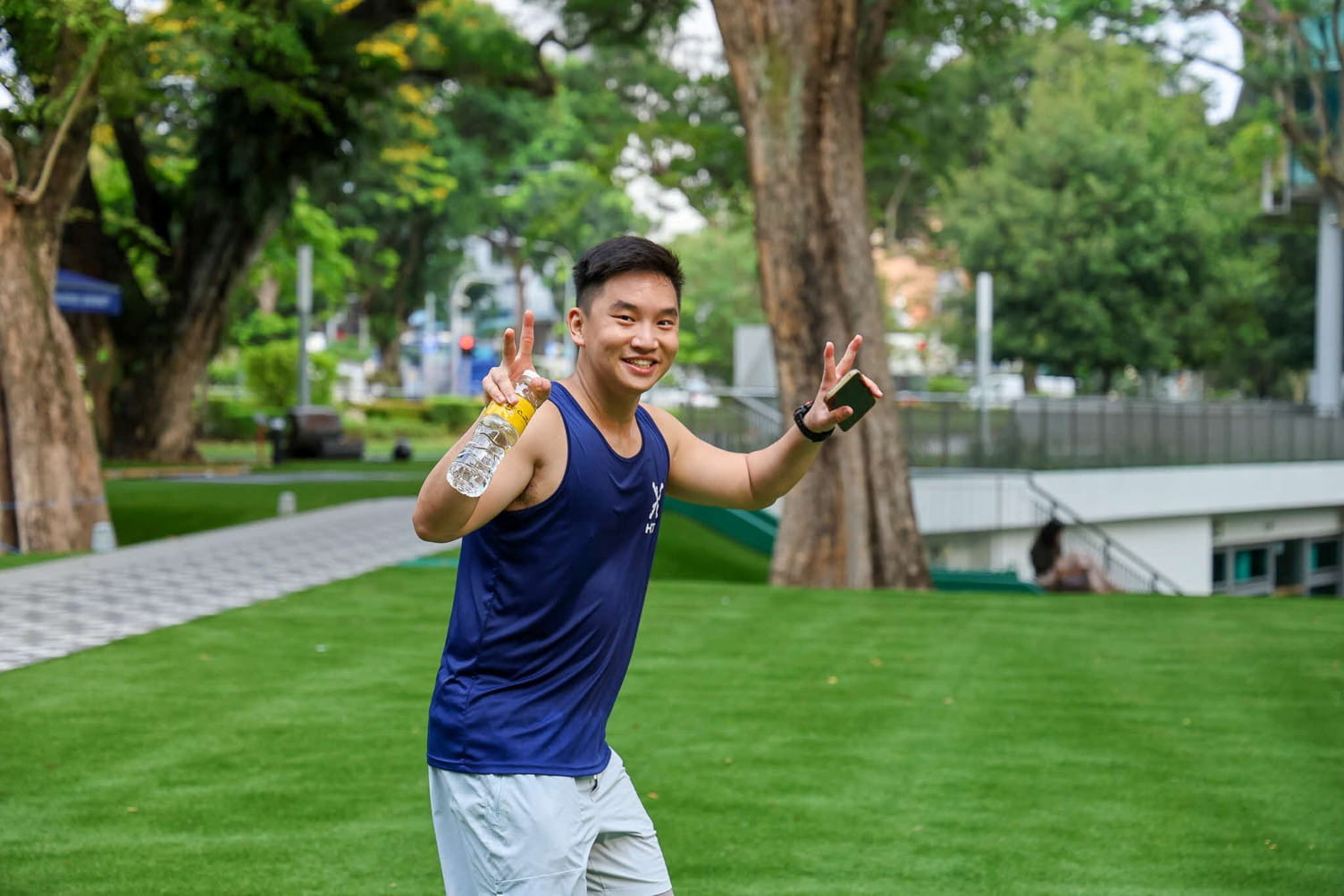 Young man posing outdoors on a manicured green lawn.