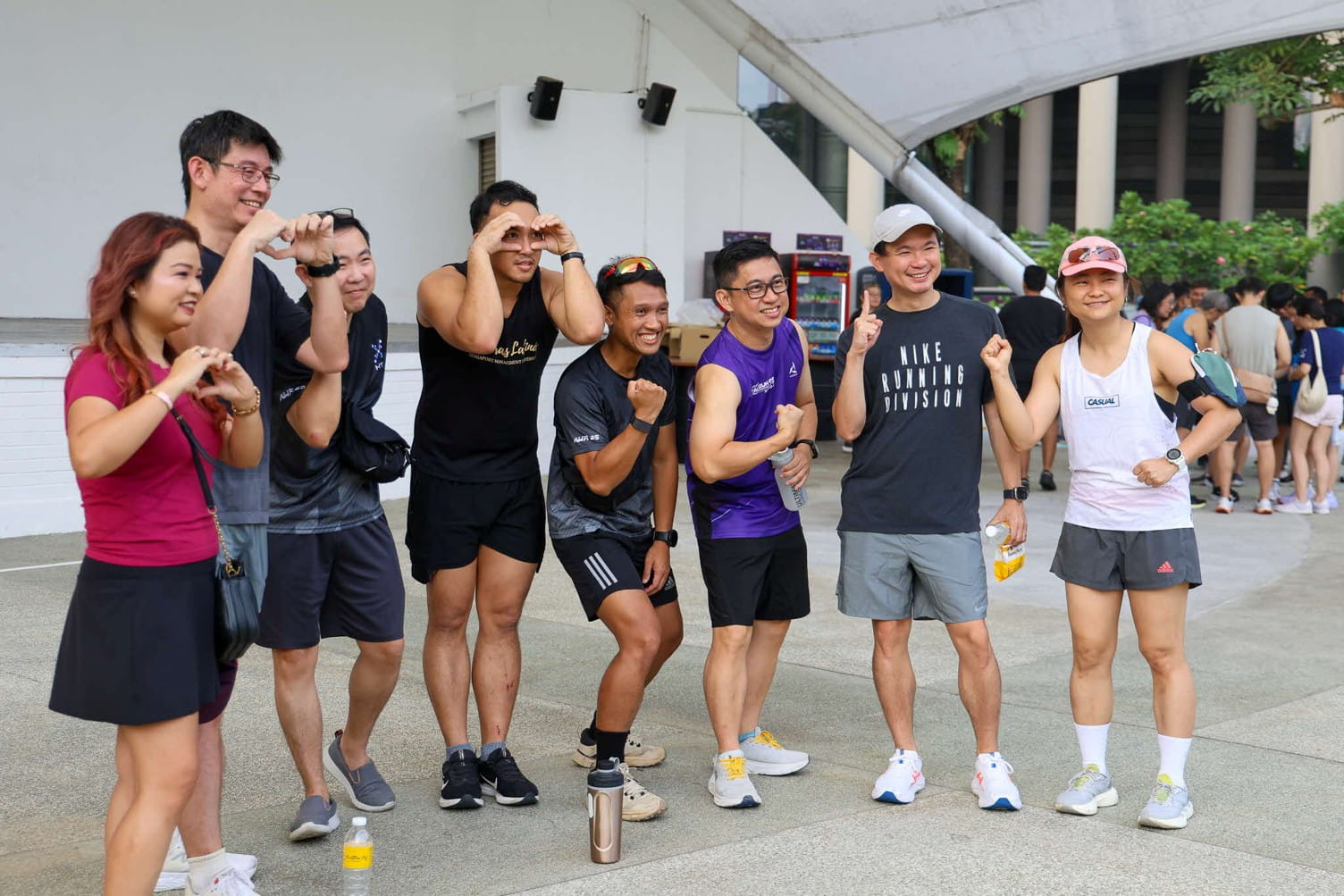 Eight adults smiling and posing outdoors.