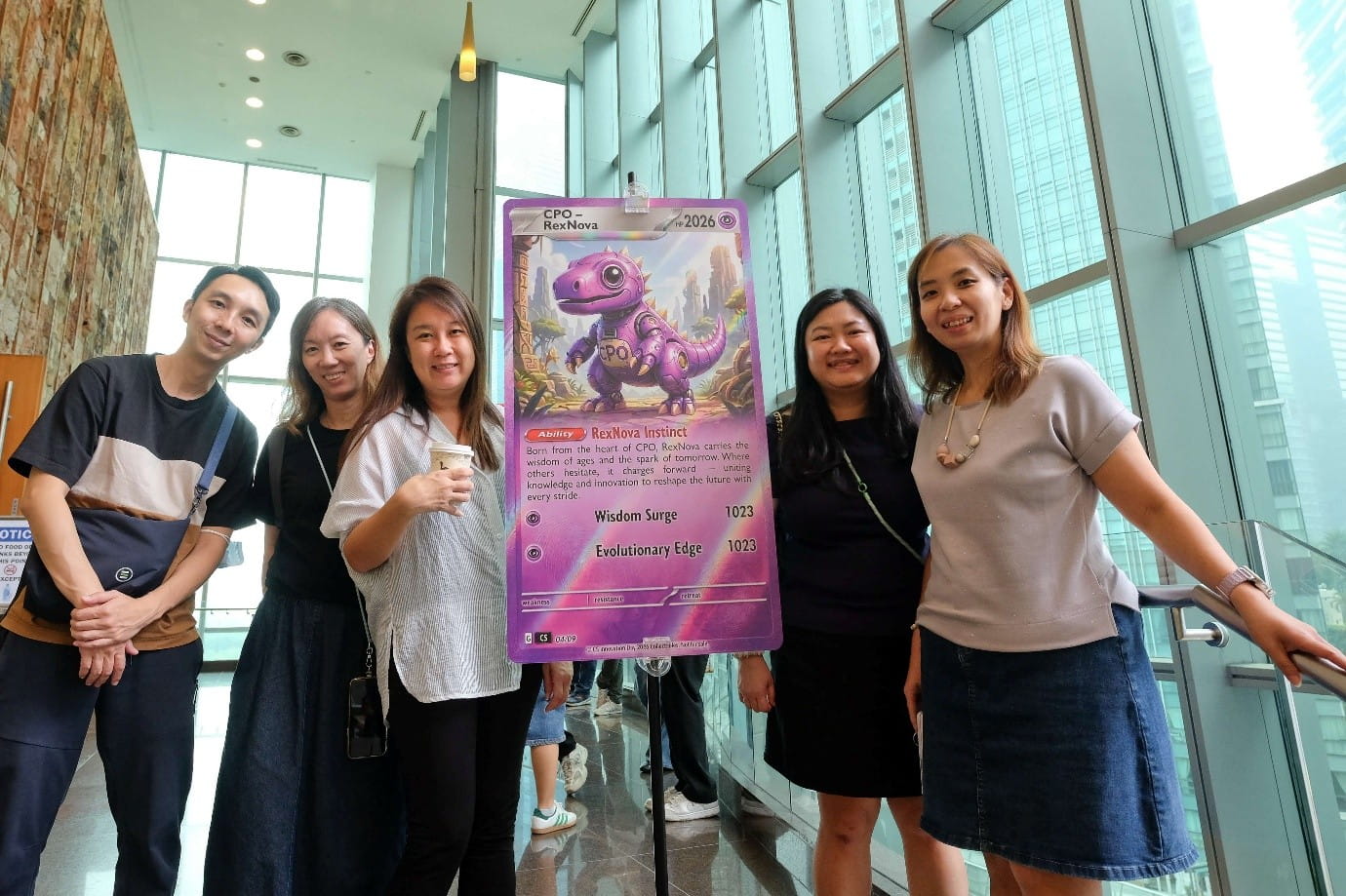 Five adults posing indoors with a "CPO - RexNova" character poster.