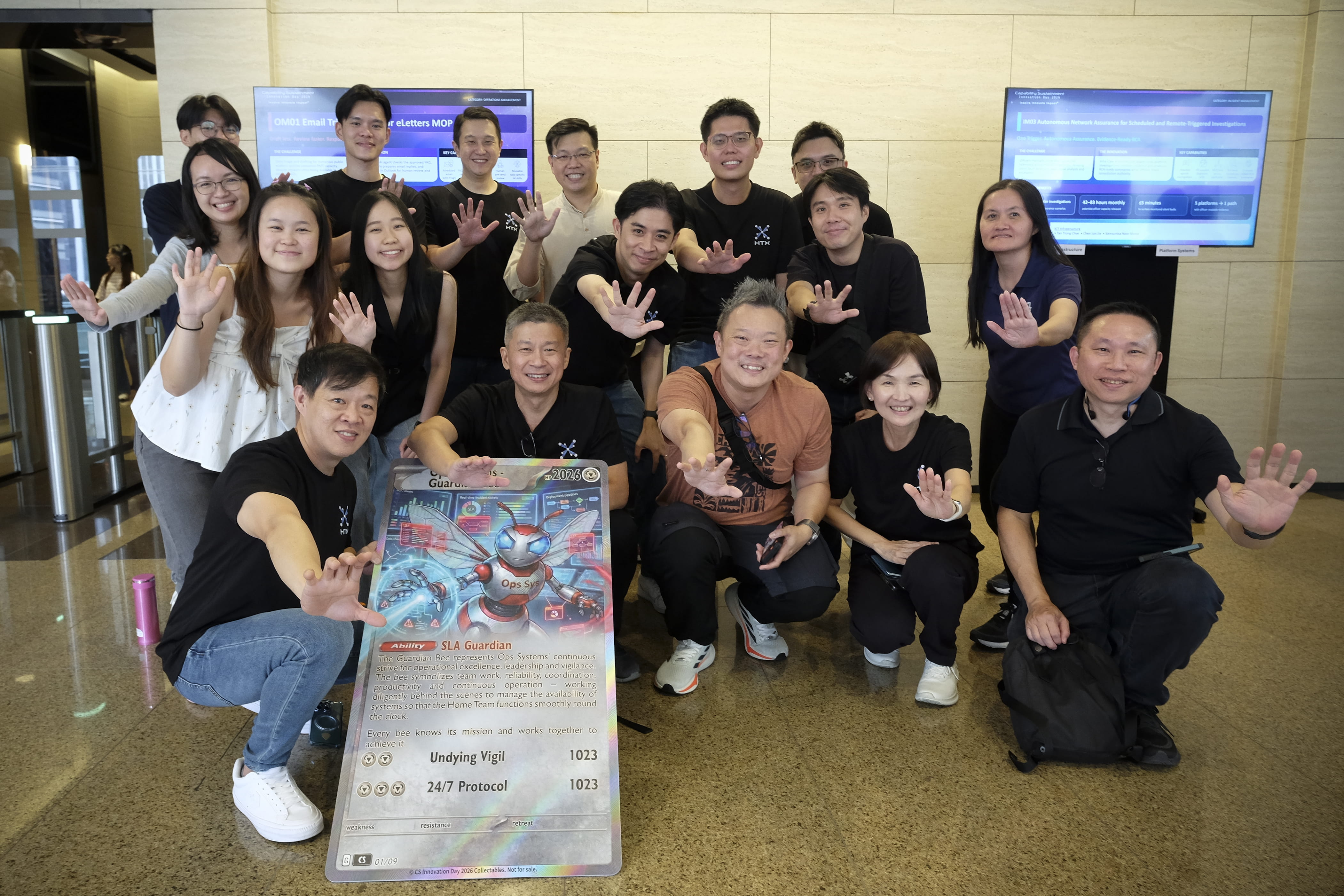 Large group posing together at a lobby with a character poster.