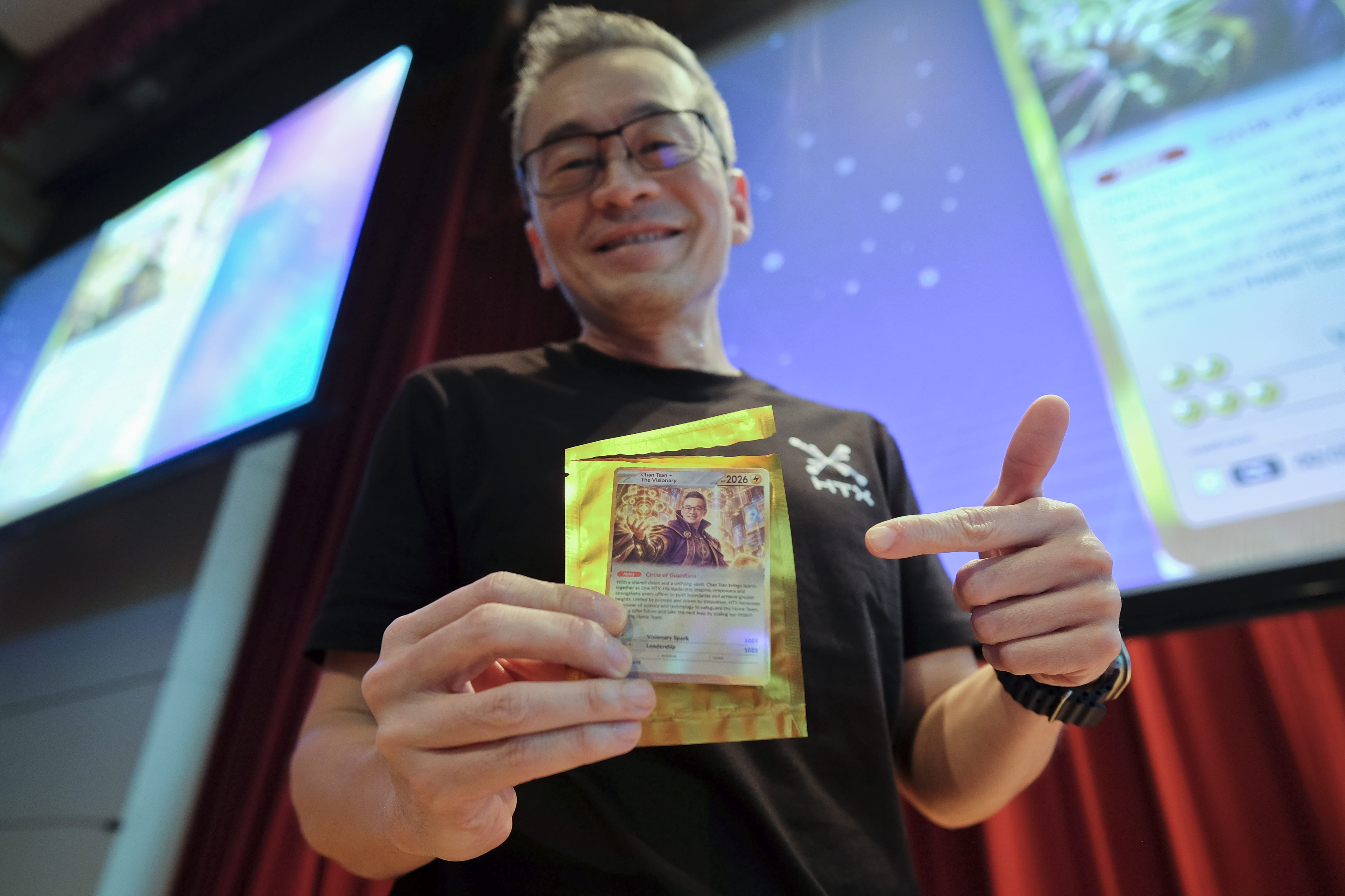 Smiling man holding a collectible trading card.