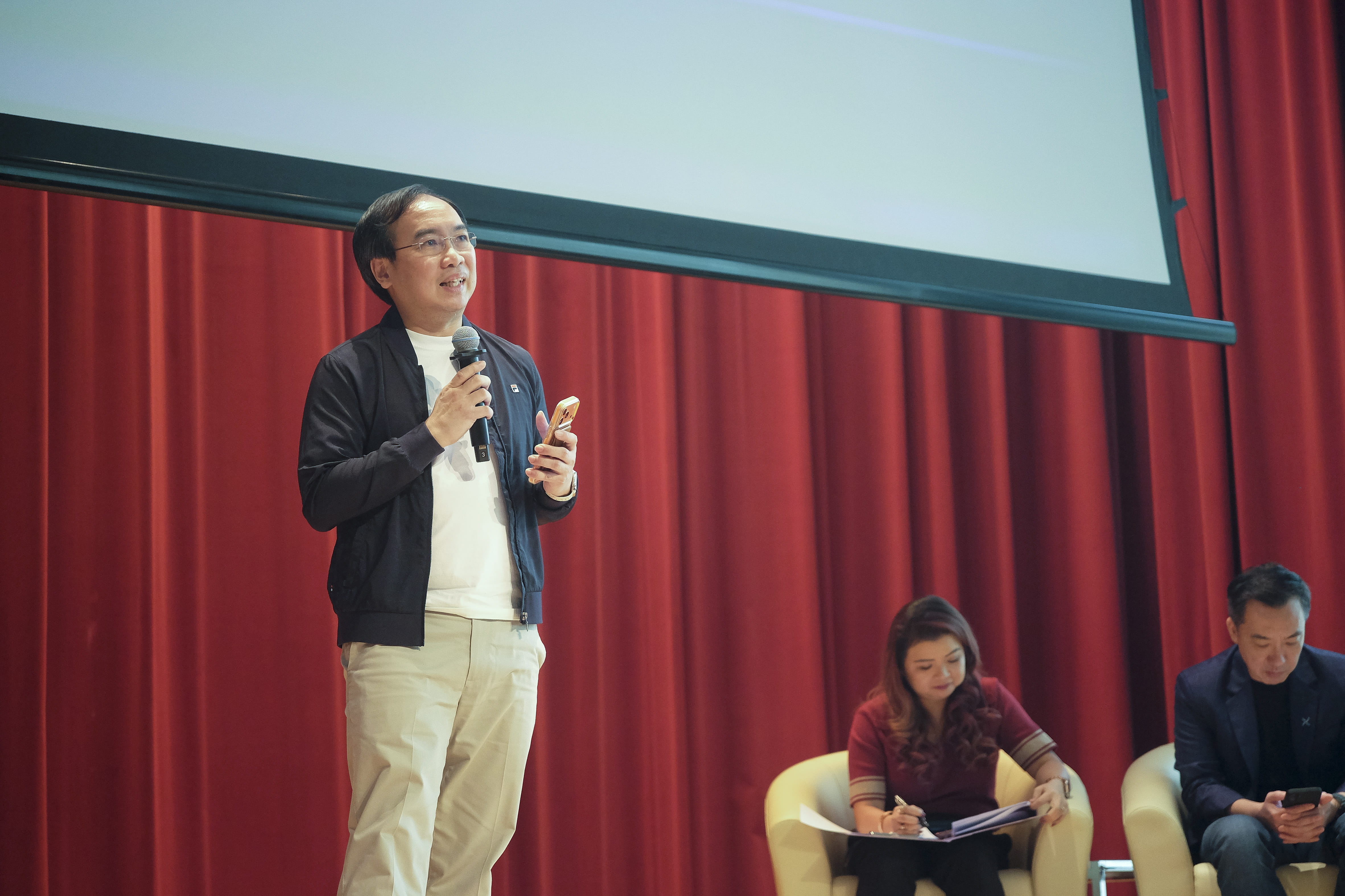 Presenter speaking into a microphone.