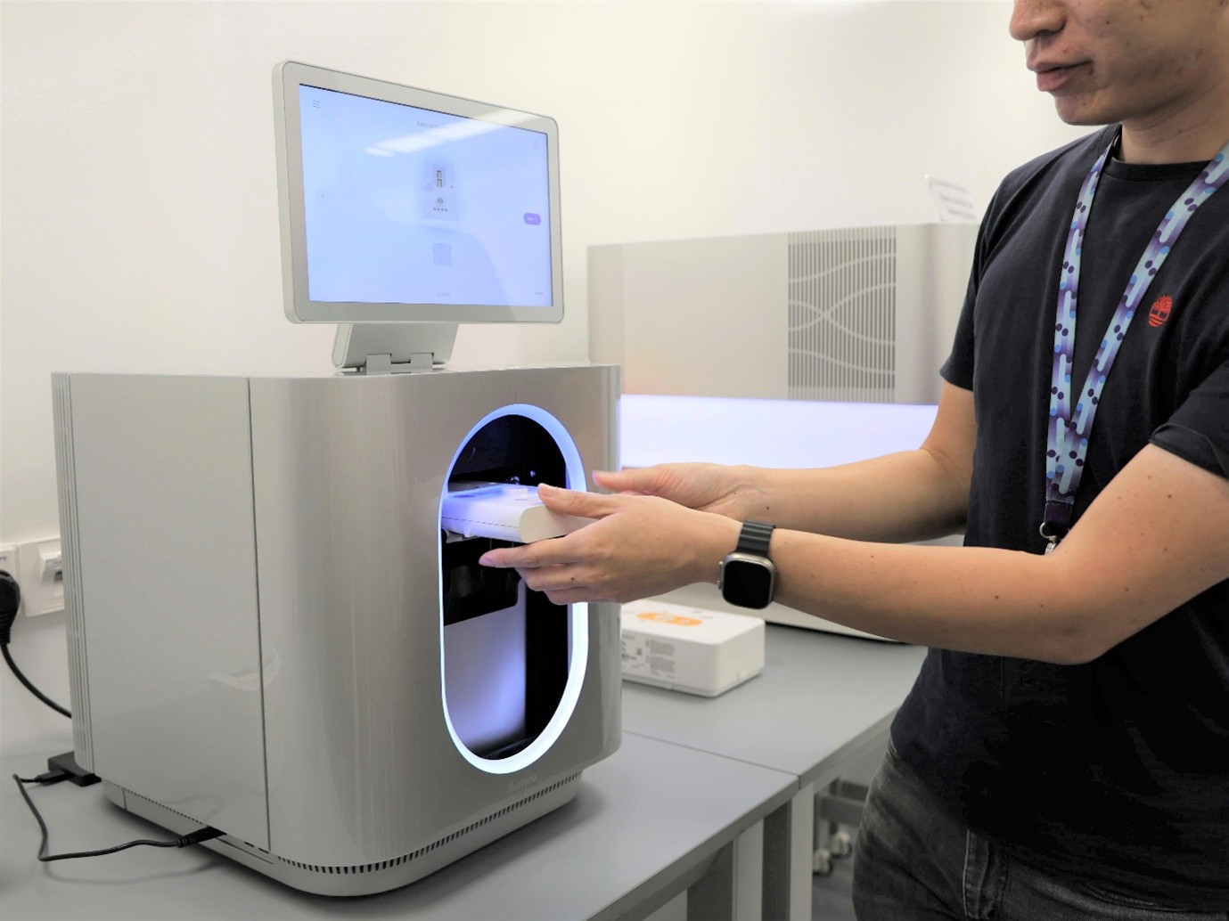 A person fitting something into a machine in a lab.