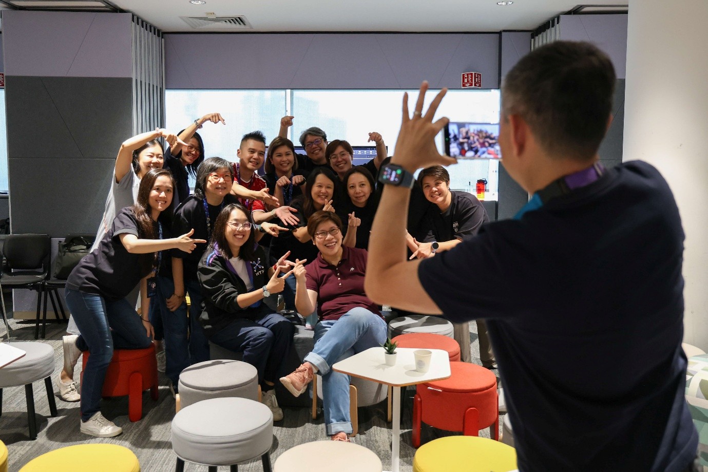 Group of colleagues posing enthusiastically for a team photo.