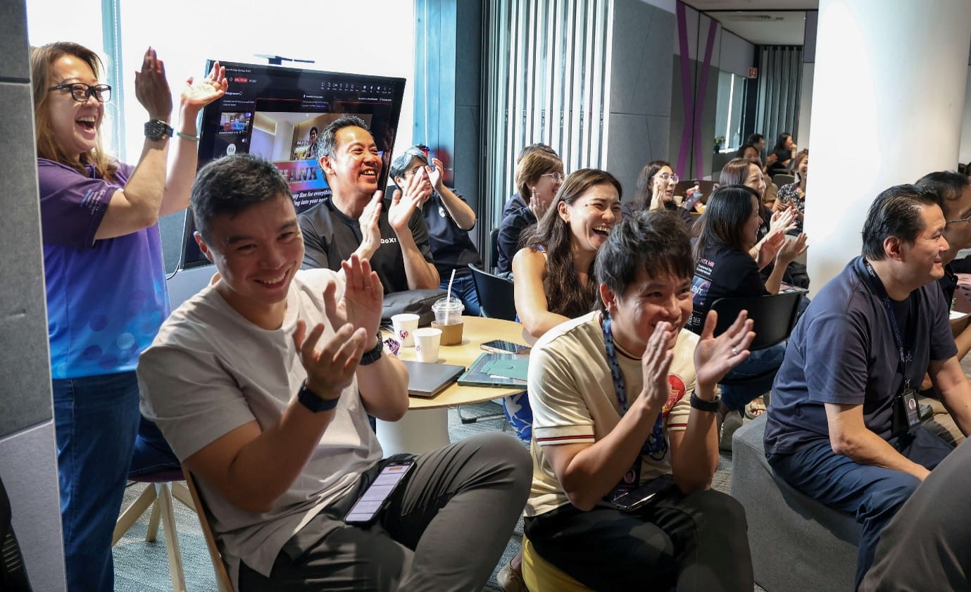 Group of audience applauding during an indoor activity.