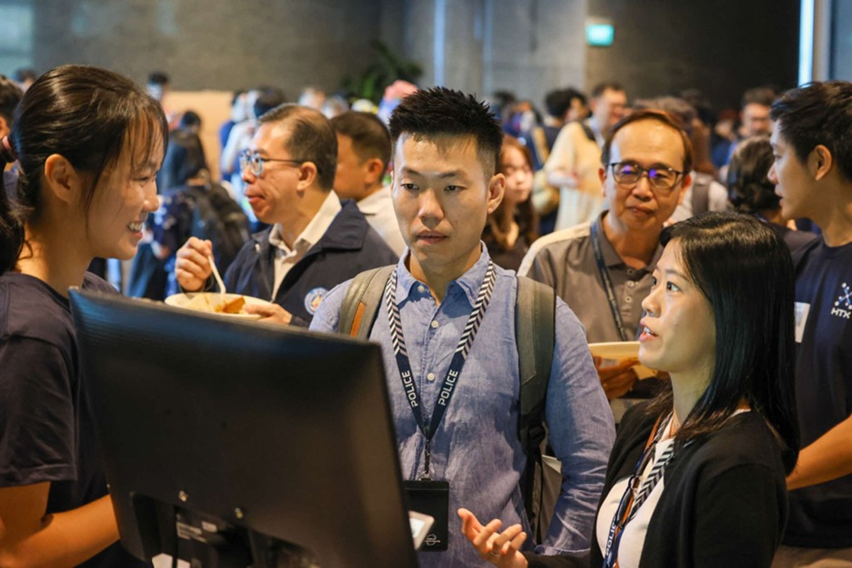 Attendees discuss around a computer monitor.