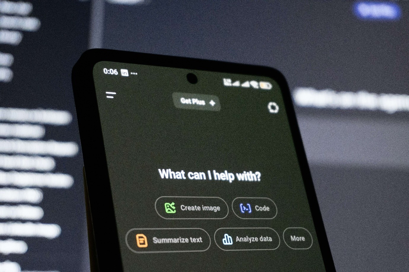 A close-up of a smartphone displaying an AI assistant interface with options for creating images, coding, and summarising text.