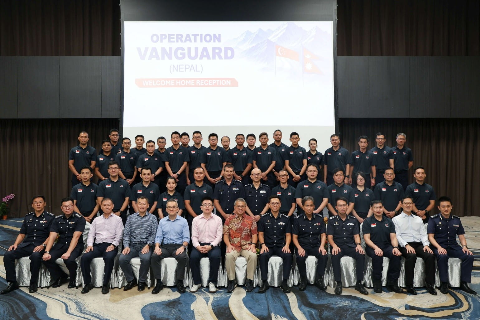Large group of personnel posing at a formal reception.