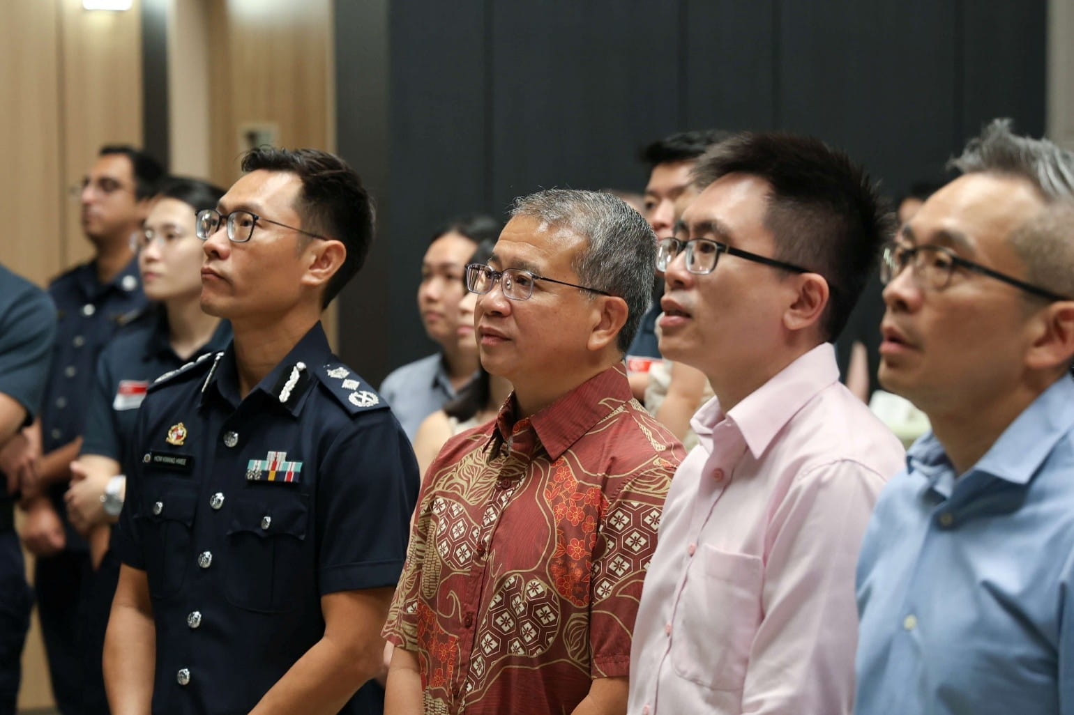Group of attendees listening attentively during an indoor presentation.