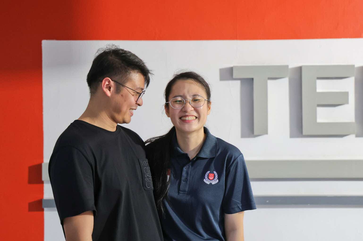 Two smiling people posing.