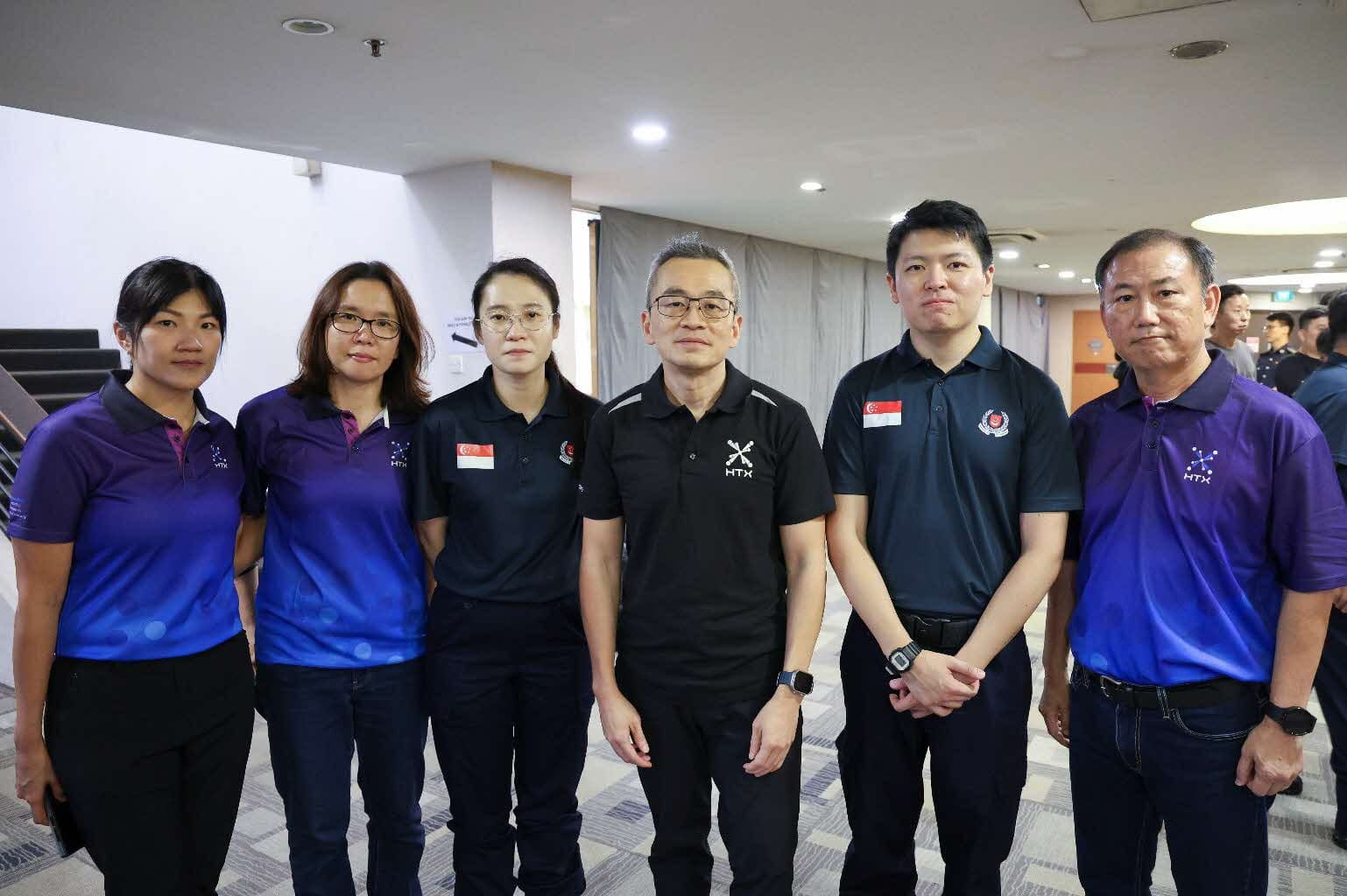 Six individuals posing indoors.