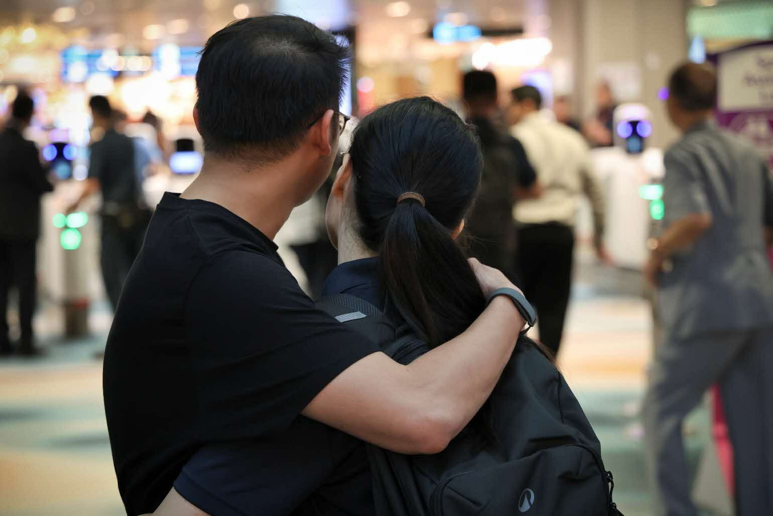 A couple embracing inside an airport terminal.